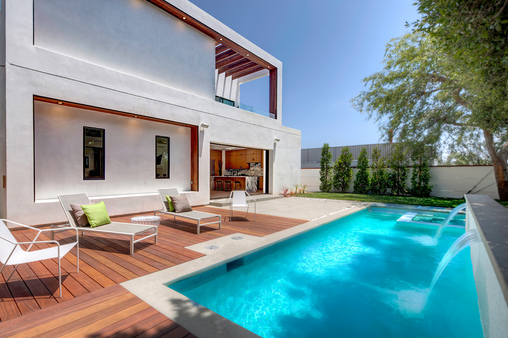 Esempio di una piscina monocorsia minimalista rettangolare dietro casa e di medie dimensioni con fontane e pedane