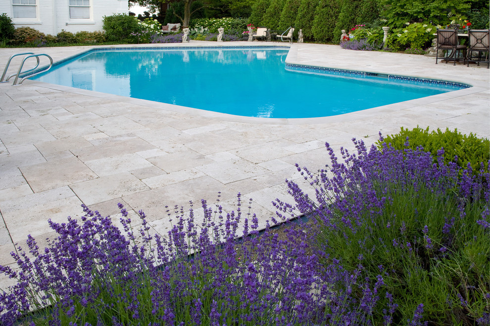 Foto på en stor medelhavsstil pool, med naturstensplattor