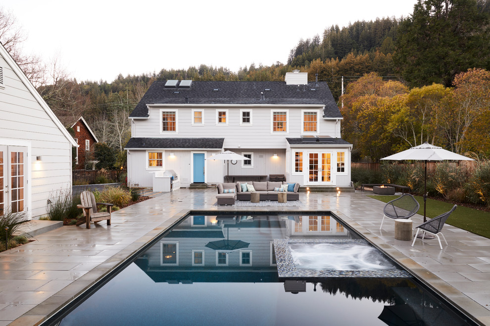 На фото: прямоугольный бассейн на заднем дворе в классическом стиле с джакузи с