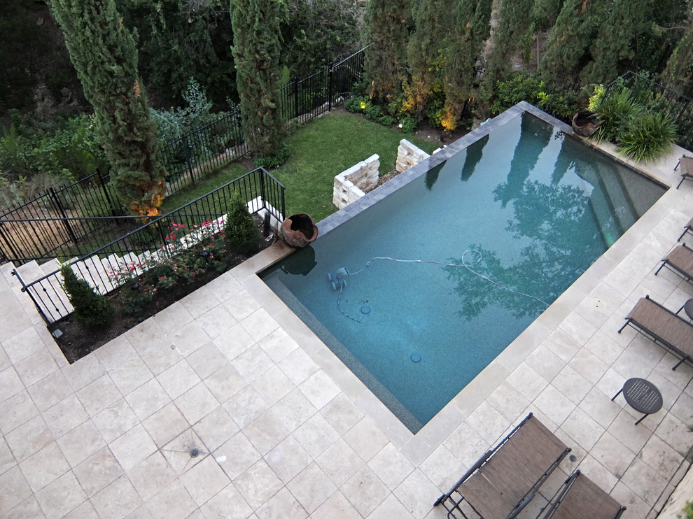 Mittelgroßer, Gefliester Mediterraner Infinity-Pool hinter dem Haus in rechteckiger Form mit Wasserspiel in Austin
