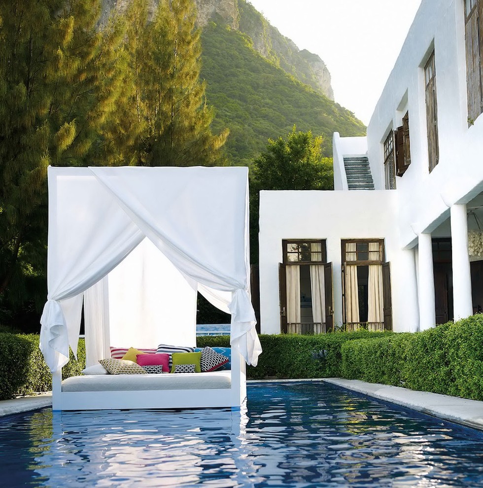 Modelo de casa de la piscina y piscina alargada mediterránea de tamaño medio rectangular en patio trasero con losas de hormigón