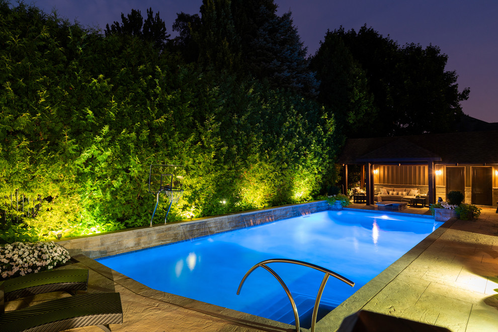 Inspiration for a large modern backyard stamped concrete and rectangular lap pool remodel in Toronto
