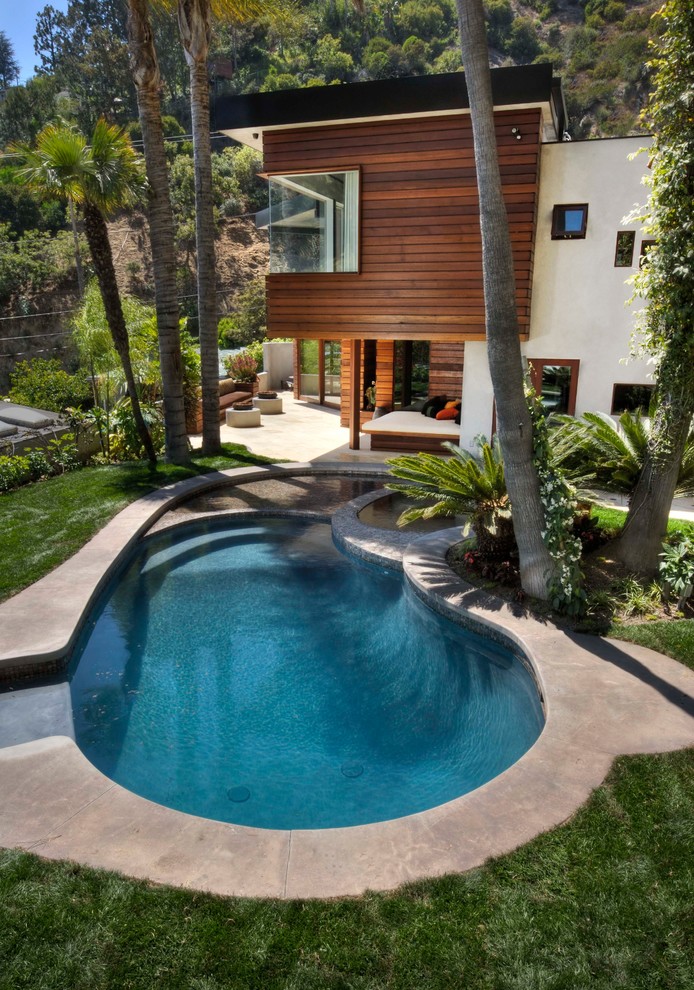 Esempio di una piscina minimal rotonda con lastre di cemento