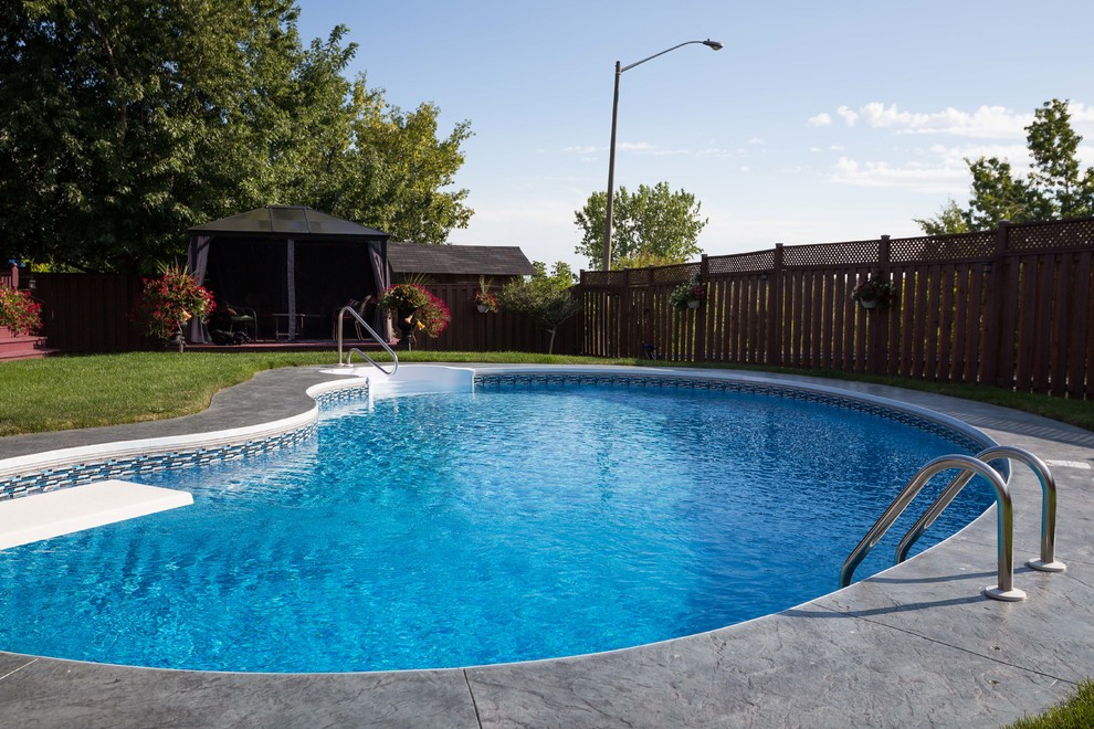 Foto de piscina moderna tipo riñón en patio trasero con suelo de hormigón estampado