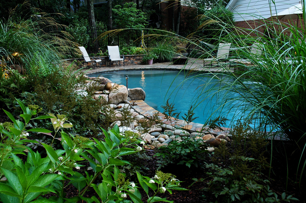 アトランタにある高級な広いトロピカルスタイルのおしゃれなプール (噴水、天然石敷き) の写真