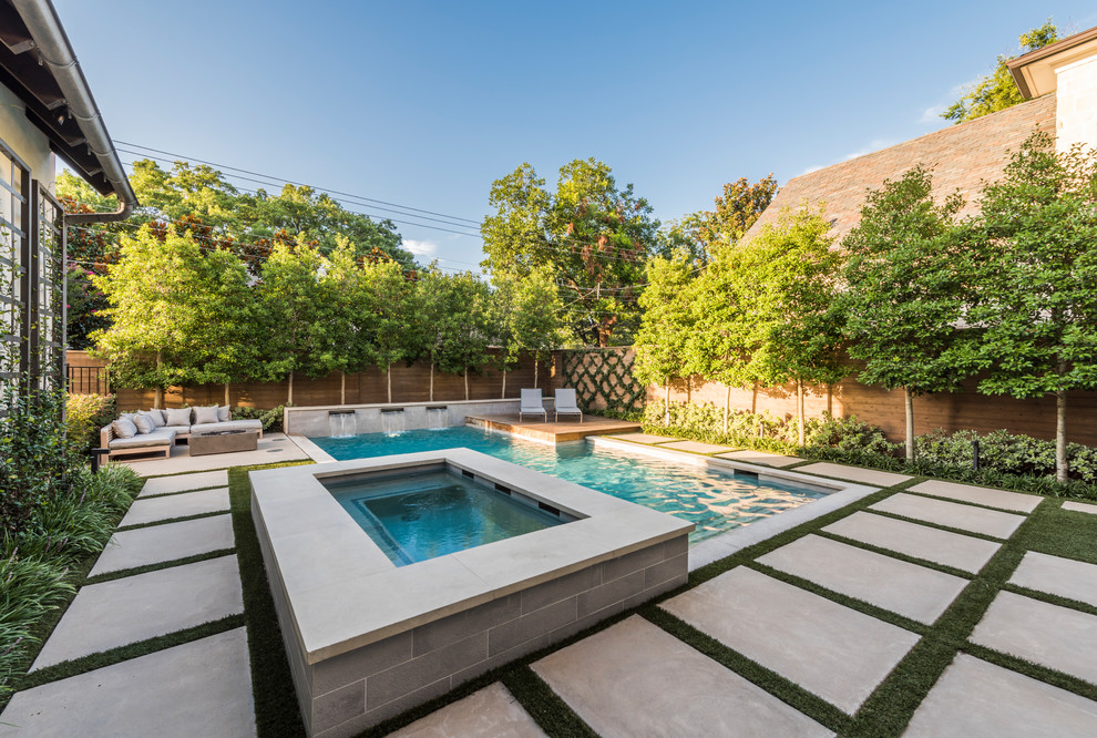 Foto de piscina alargada contemporánea de tamaño medio rectangular en patio trasero con adoquines de hormigón