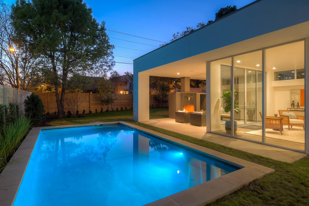 Immagine di una piscina monocorsia contemporanea rettangolare di medie dimensioni e dietro casa con una dépendance a bordo piscina e lastre di cemento