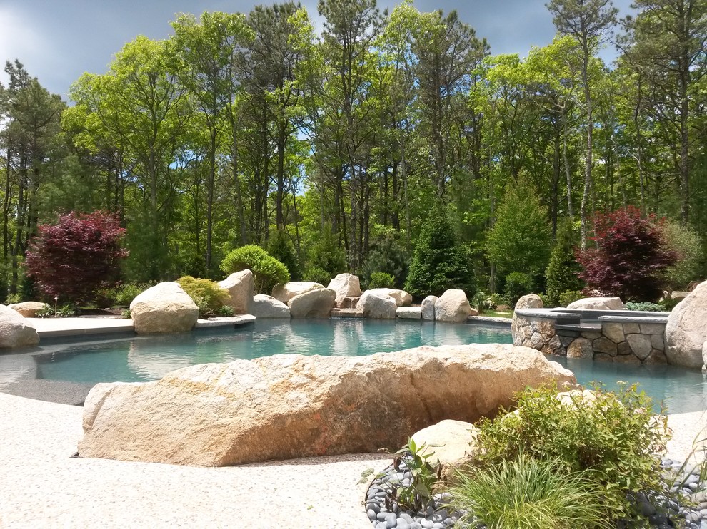 Ejemplo de piscinas y jacuzzis naturales mediterráneos extra grandes redondeados en patio trasero con losas de hormigón