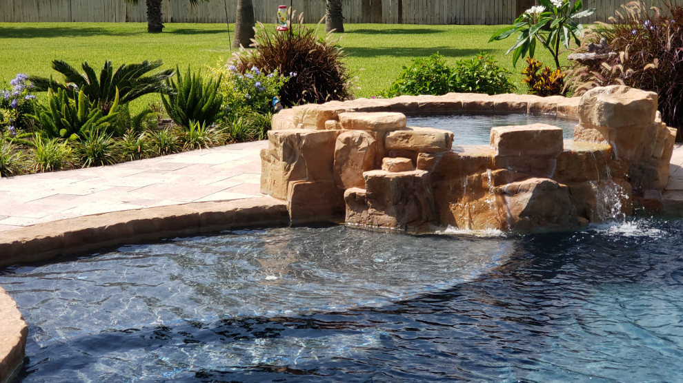 Cette image montre une grande piscine naturelle et arrière chalet sur mesure avec des pavés en pierre naturelle.