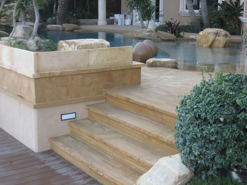 Idee per una piscina design con pavimentazioni in pietra naturale