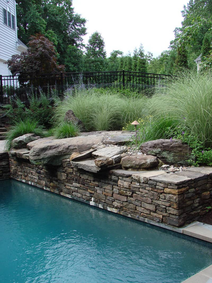 Immagine di una piscina di medie dimensioni e dietro casa con pavimentazioni in pietra naturale
