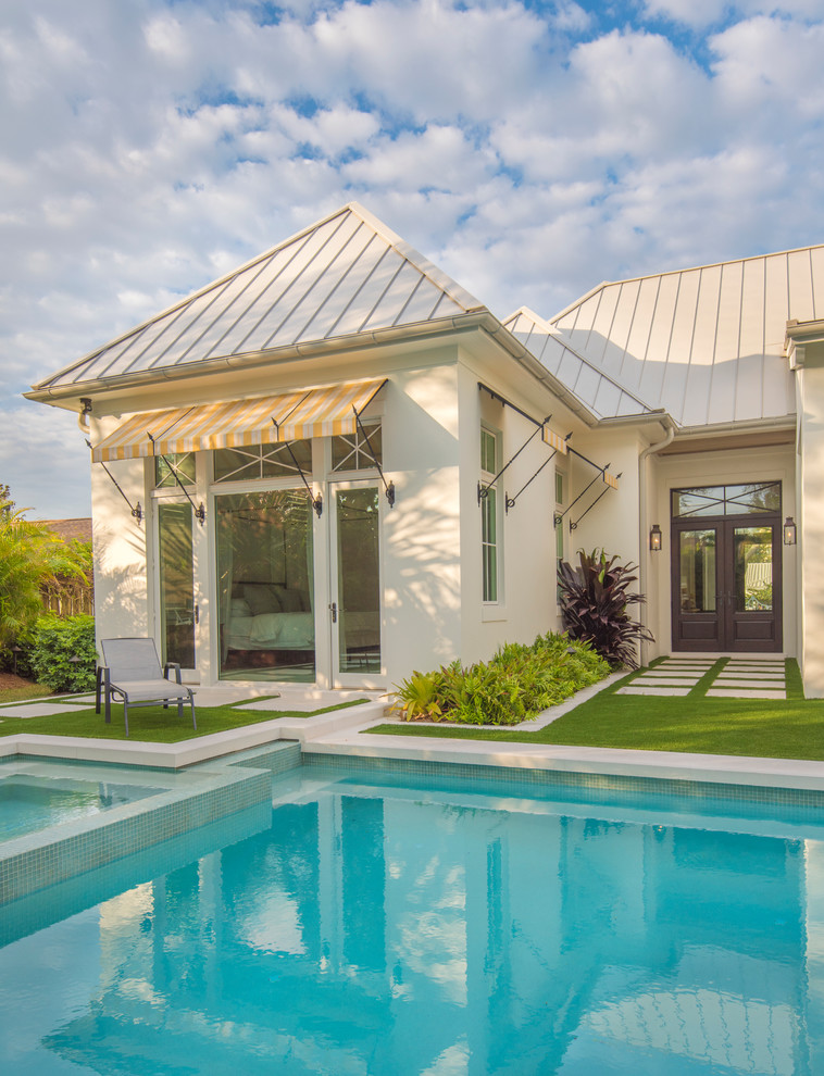 Großer Landhaus Pool hinter dem Haus in rechteckiger Form mit Natursteinplatten in Tampa