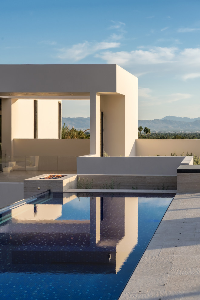 Photo of an expansive contemporary roof custom shaped infinity swimming pool in Phoenix with a water feature and tiled flooring.