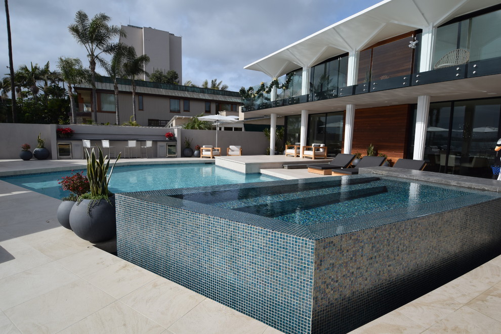 Immagine di una piscina monocorsia moderna personalizzata di medie dimensioni e dietro casa con una vasca idromassaggio e piastrelle