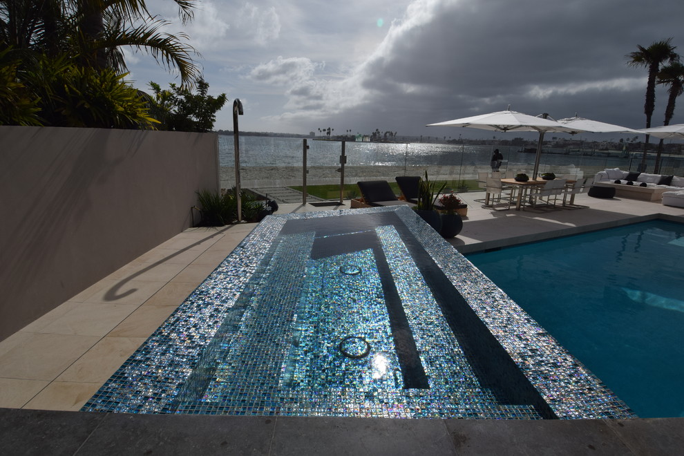 Foto di una piscina monocorsia moderna personalizzata dietro casa e di medie dimensioni con una vasca idromassaggio e piastrelle