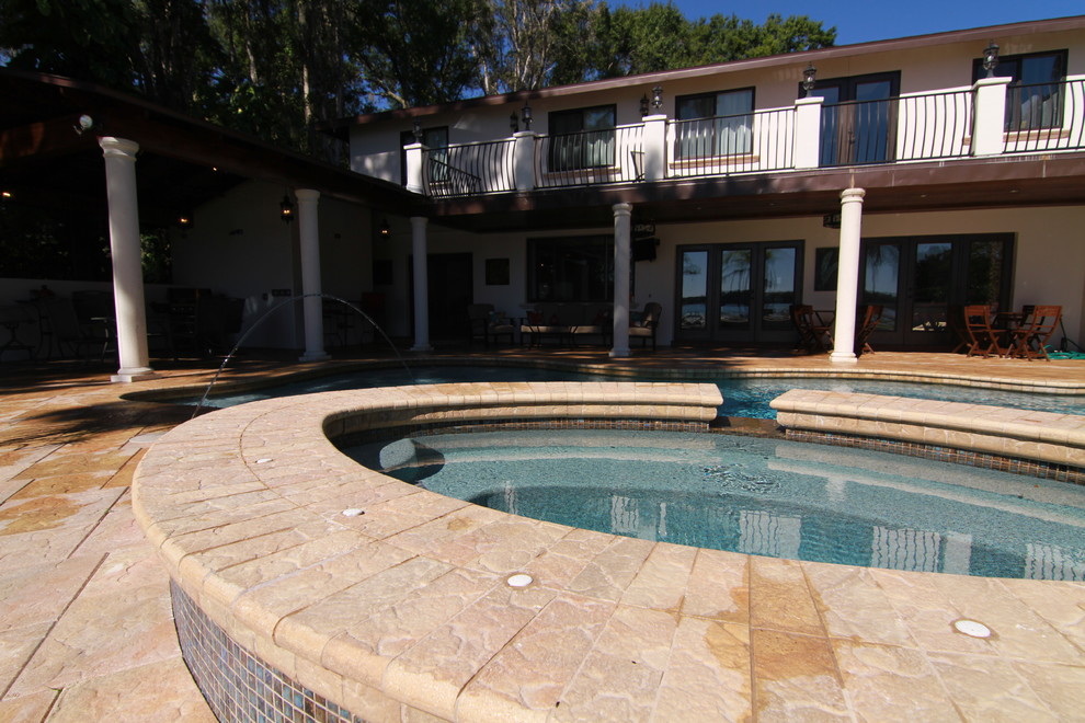 Ejemplo de piscinas y jacuzzis naturales mediterráneos grandes a medida en patio trasero con adoquines de hormigón