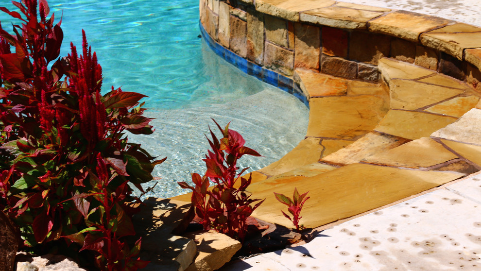 Foto di una grande piscina naturale stile americano personalizzata dietro casa con fontane
