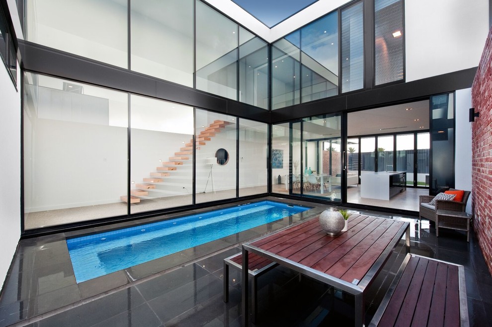 Cette photo montre une petite piscine tendance sur mesure avec une cour et une terrasse en bois.