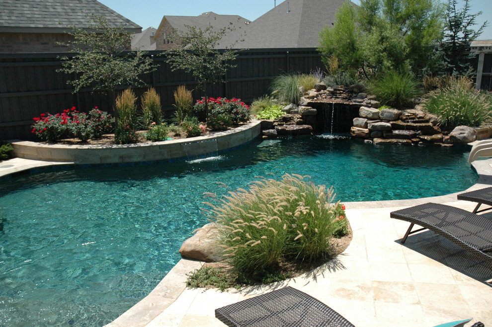Esempio di una grande piscina naturale rustica personalizzata dietro casa con pavimentazioni in pietra naturale e una vasca idromassaggio