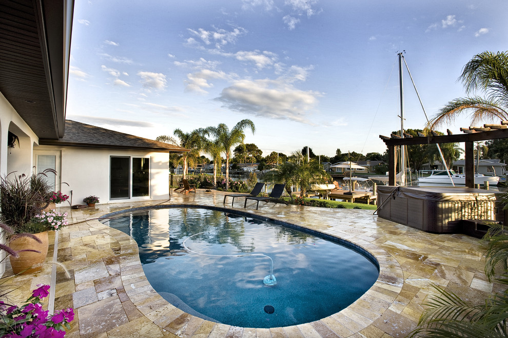 Example of a mid-sized classic backyard tile and kidney-shaped lap hot tub design in Tampa