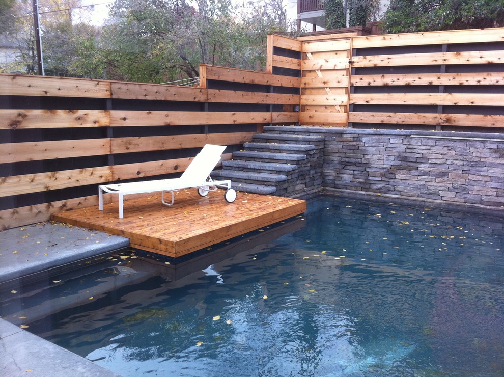 Réalisation d'une piscine design sur mesure avec une terrasse en bois.