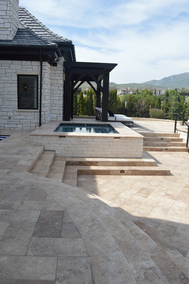 Diseño de piscina con tobogán alargada clásica renovada rectangular en patio trasero con suelo de baldosas