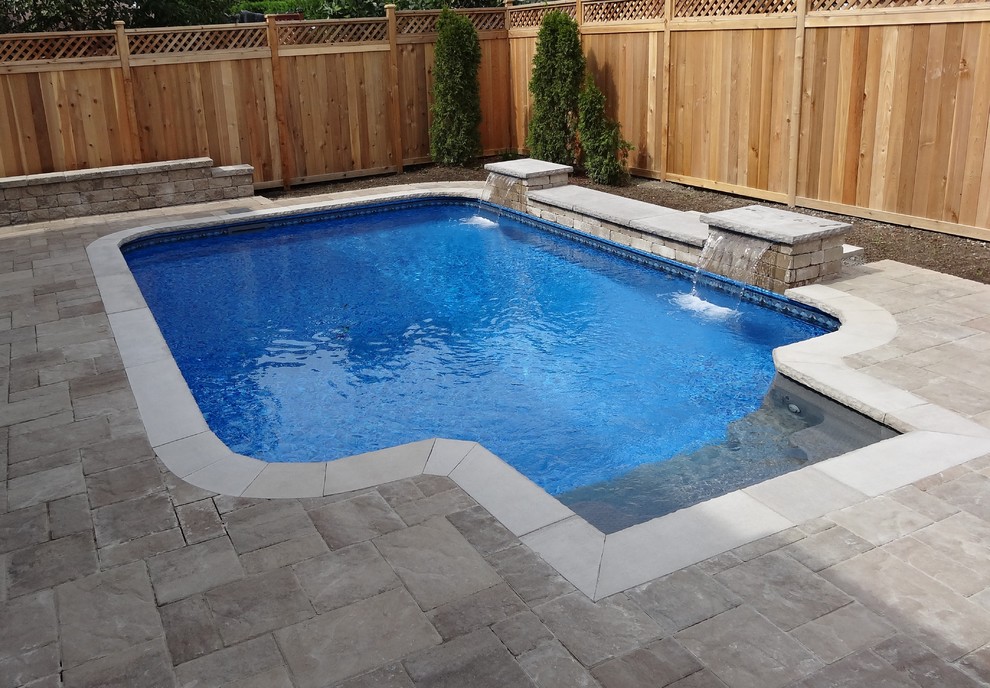 Immagine di una piscina naturale chic personalizzata dietro casa con pavimentazioni in mattoni
