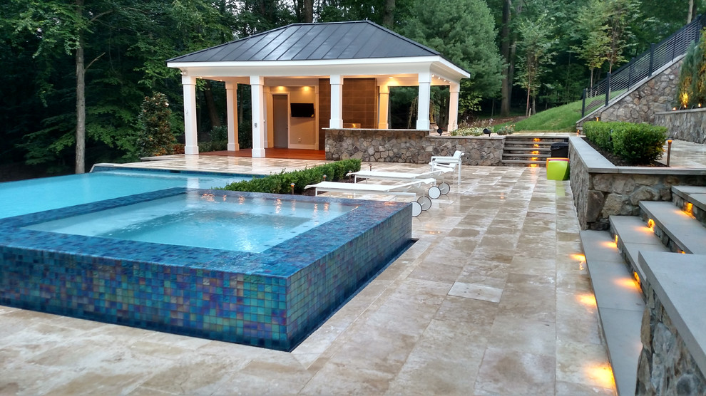 Пример оригинального дизайна: огромный прямоугольный бассейн-инфинити на заднем дворе в стиле модернизм с домиком у бассейна и покрытием из каменной брусчатки