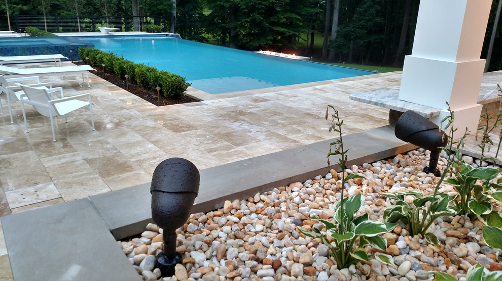 Imagen de casa de la piscina y piscina infinita moderna extra grande rectangular en patio trasero con adoquines de piedra natural