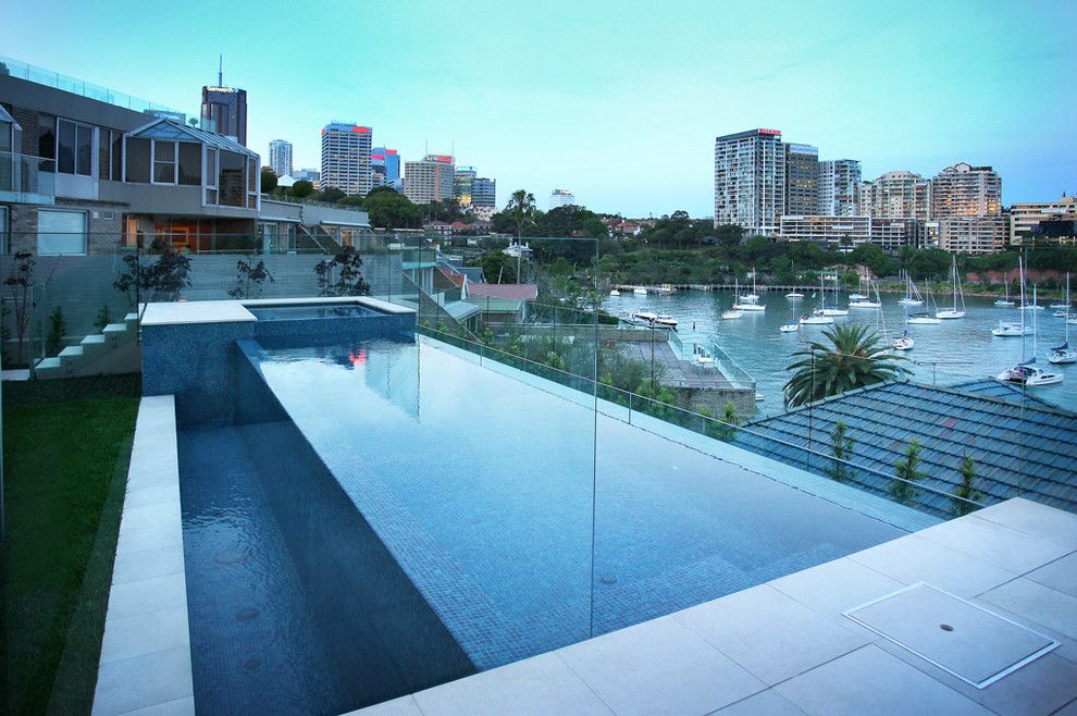 Foto de piscina con fuente elevada actual de tamaño medio rectangular en patio trasero