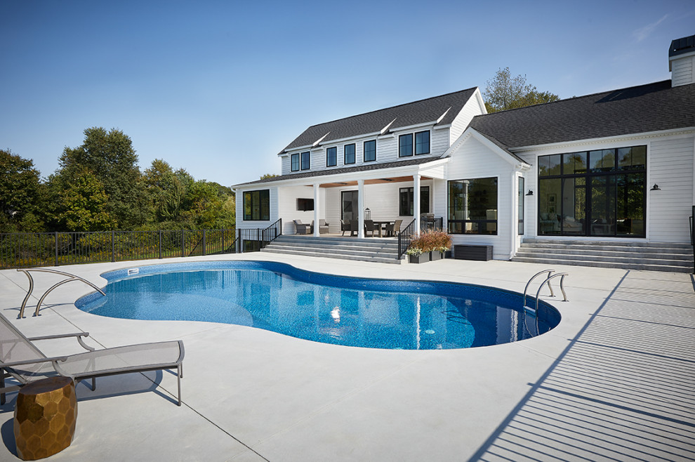 Ispirazione per una piscina monocorsia personalizzata di medie dimensioni e dietro casa con lastre di cemento