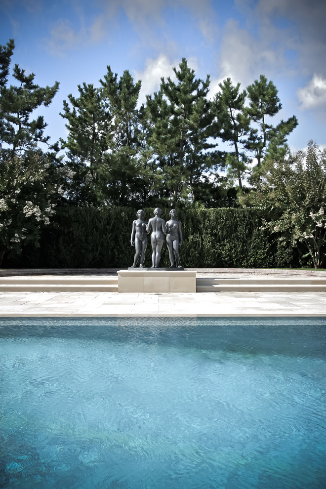 Modelo de piscinas y jacuzzis infinitos actuales grandes rectangulares en patio trasero con adoquines de piedra natural
