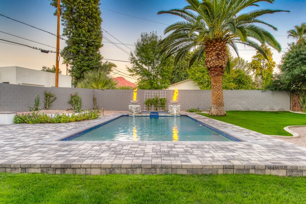 Ejemplo de piscinas y jacuzzis naturales de estilo americano de tamaño medio rectangulares en patio trasero con adoquines de hormigón