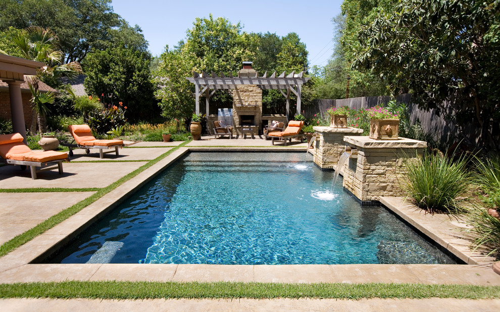 Cette image montre une piscine naturelle et arrière traditionnelle rectangle et de taille moyenne avec un point d'eau et des pavés en pierre naturelle.