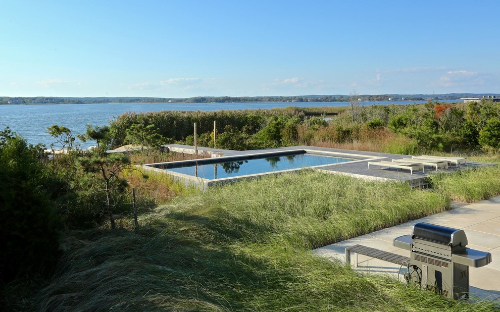 Idee per una grande piscina monocorsia tradizionale rettangolare dietro casa con pavimentazioni in cemento