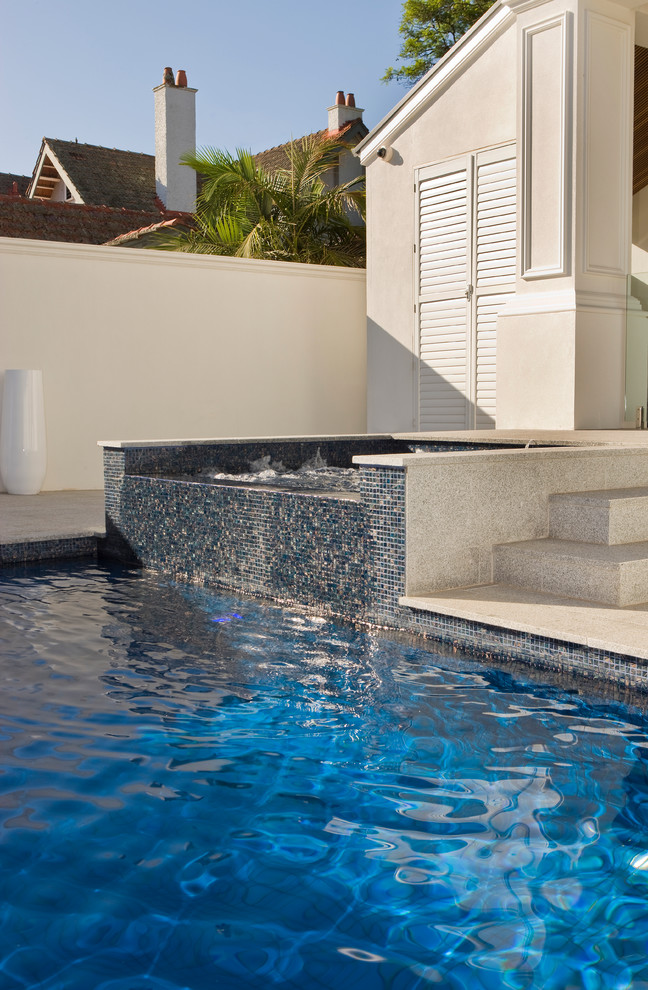 Стильный дизайн: естественный, прямоугольный бассейн среднего размера на заднем дворе в современном стиле с фонтаном и покрытием из каменной брусчатки - последний тренд