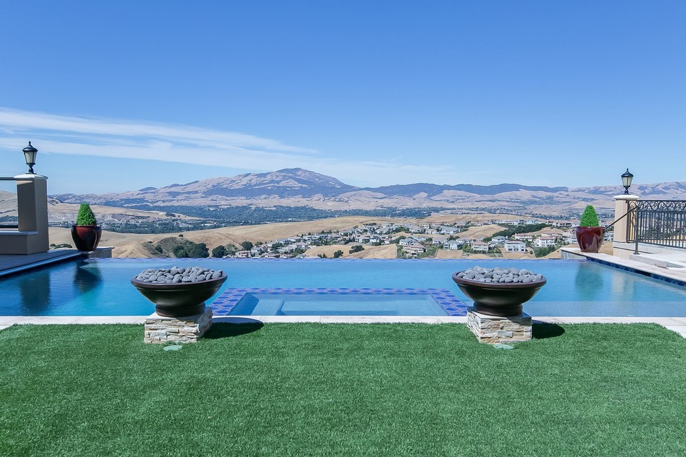 Diseño de piscinas y jacuzzis infinitos mediterráneos de tamaño medio rectangulares en patio trasero con suelo de hormigón estampado