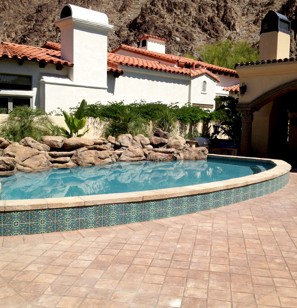 Источник вдохновения для домашнего уюта: большой бассейн произвольной формы на заднем дворе в средиземноморском стиле с покрытием из плитки