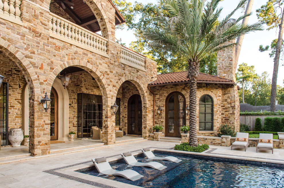 Ispirazione per una grande piscina monocorsia mediterranea rettangolare dietro casa con una vasca idromassaggio e piastrelle