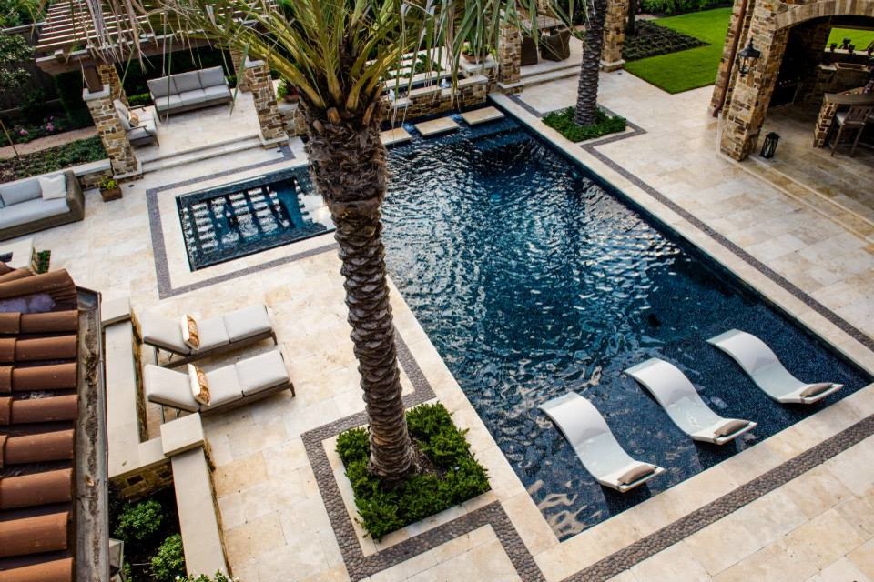 Immagine di una grande piscina monocorsia mediterranea rettangolare dietro casa con una vasca idromassaggio e piastrelle