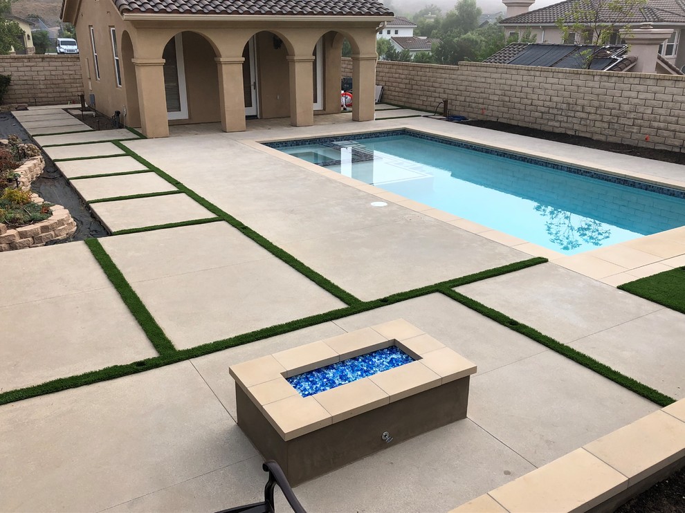 Ispirazione per una piscina monocorsia mediterranea rettangolare di medie dimensioni e dietro casa con lastre di cemento
