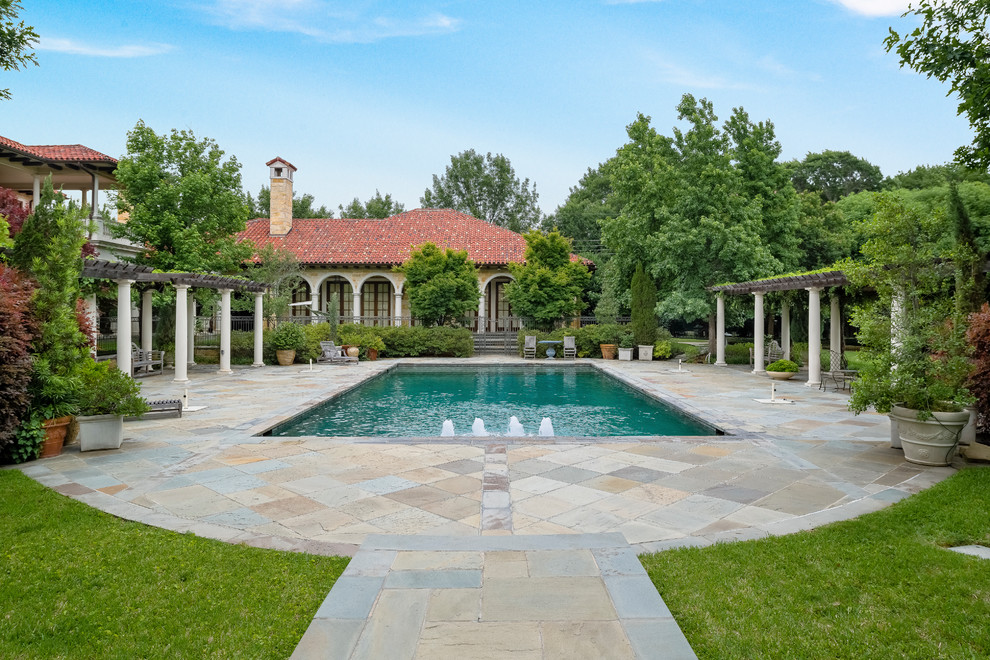 Example of a tuscan backyard rectangular pool fountain design in Dallas