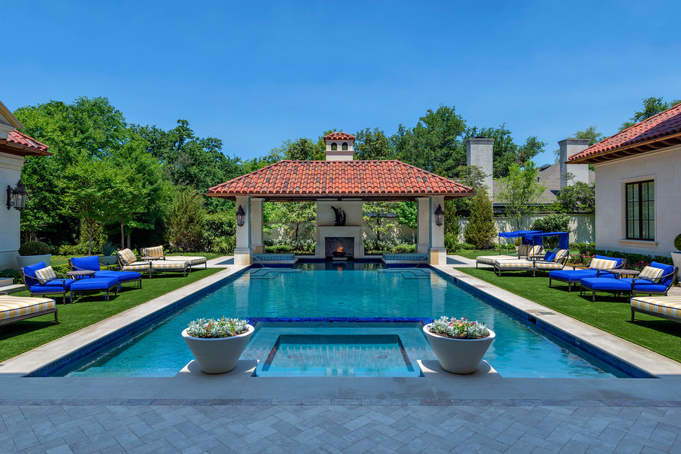 Large tuscan backyard rectangular and concrete paver pool photo in Dallas
