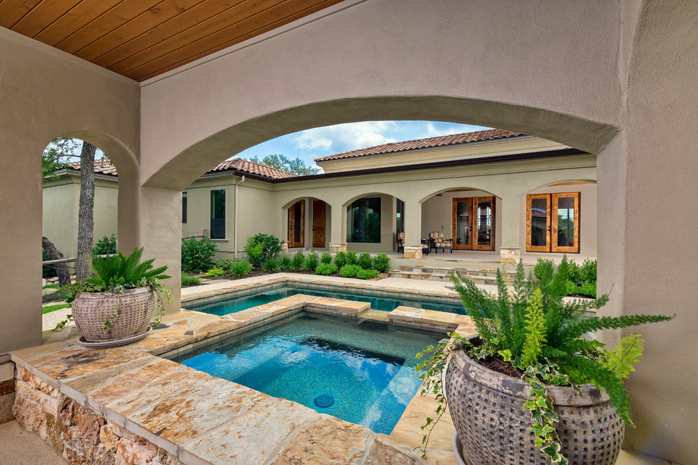 Idee per una grande piscina monocorsia mediterranea rettangolare dietro casa con fontane e pavimentazioni in pietra naturale
