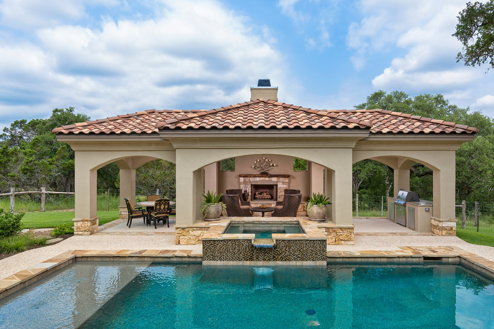 На фото: прямоугольный бассейн на заднем дворе в средиземноморском стиле с джакузи и покрытием из каменной брусчатки с