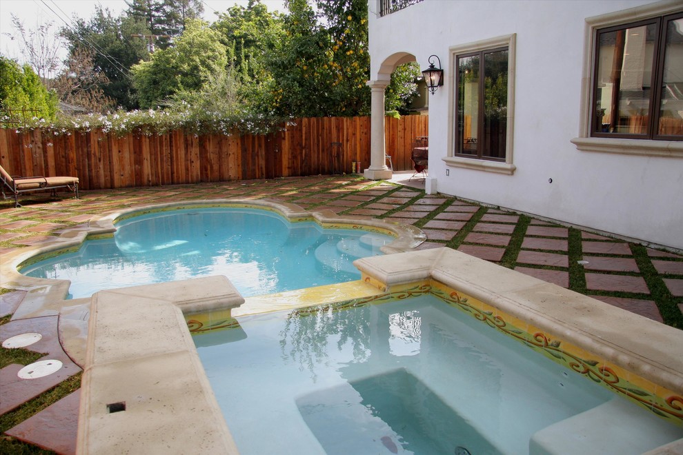 Modelo de piscinas y jacuzzis alargados mediterráneos grandes a medida en patio trasero con adoquines de hormigón