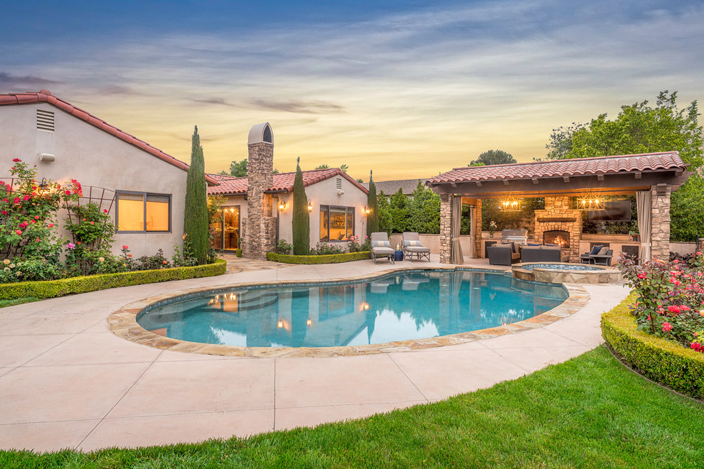This is an example of a medium sized mediterranean back kidney-shaped swimming pool in Los Angeles with a bbq area.