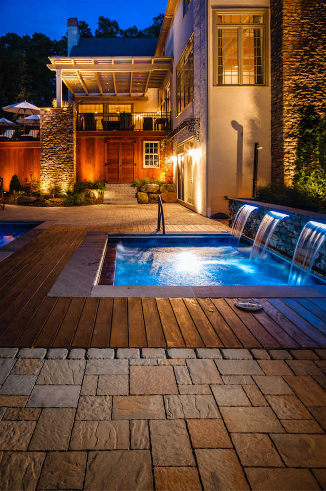 Imagen de piscina mediterránea grande en patio trasero con adoquines de hormigón