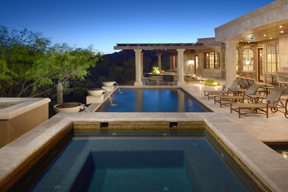 Foto de piscina infinita mediterránea de tamaño medio rectangular en patio trasero con adoquines de hormigón