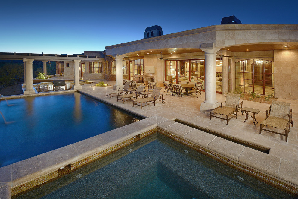 Modelo de piscina infinita mediterránea de tamaño medio rectangular en patio trasero con adoquines de hormigón
